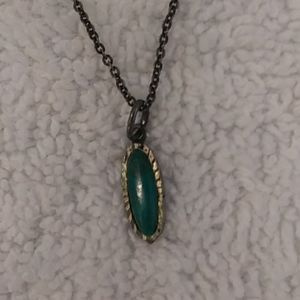Longer silver necklace with dark green stone.